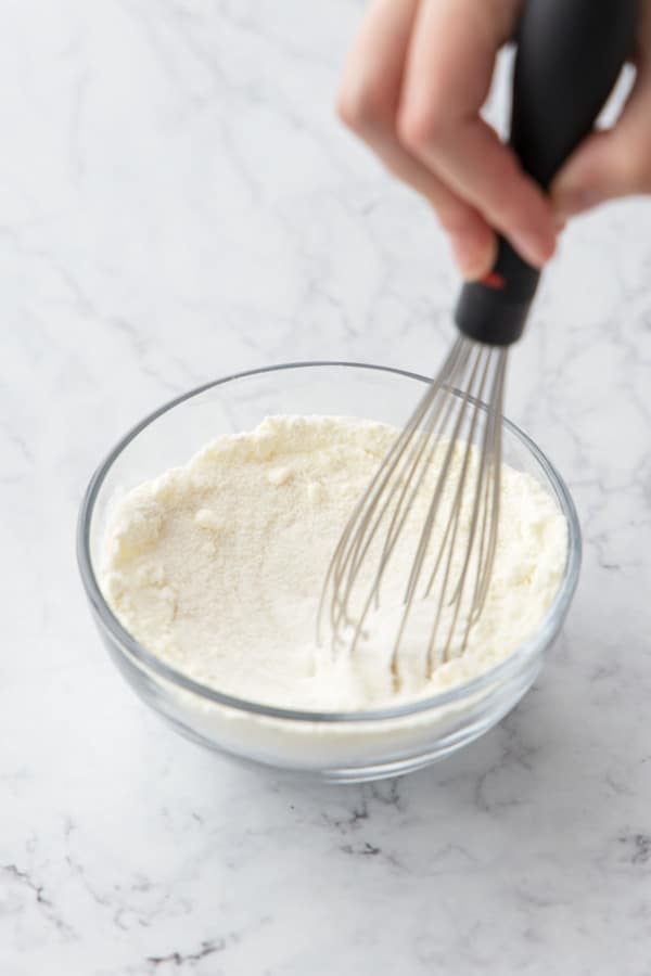 Whisking bowl of granulated sugar, milk powder and guar gum.