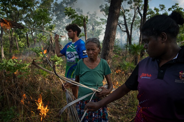 A traditional land owner in Kakadu sets fire to bushland with the help of family, for traditional controlled fire management in Australia.