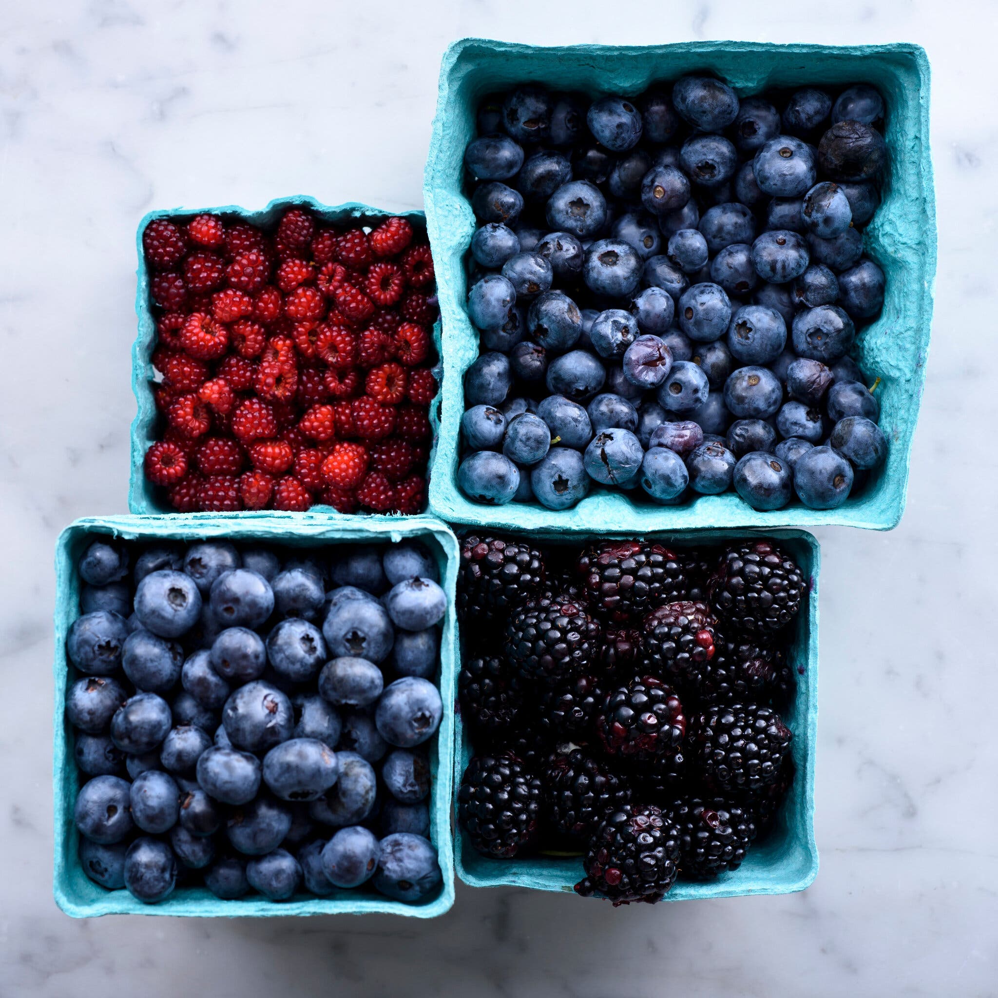 Cardboard cartons are filled with fresh berries.